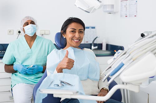 woman-giving-thumbs-up-in-dental-chair